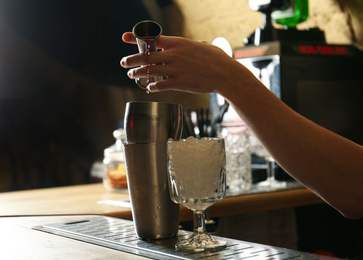 Photo of Bartender preparing fresh alcoholic cocktail at bar counter, closeup