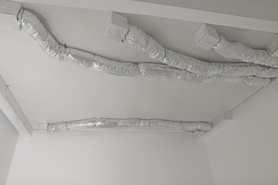 Photo of Ceiling with modern ventilation system in renovated room