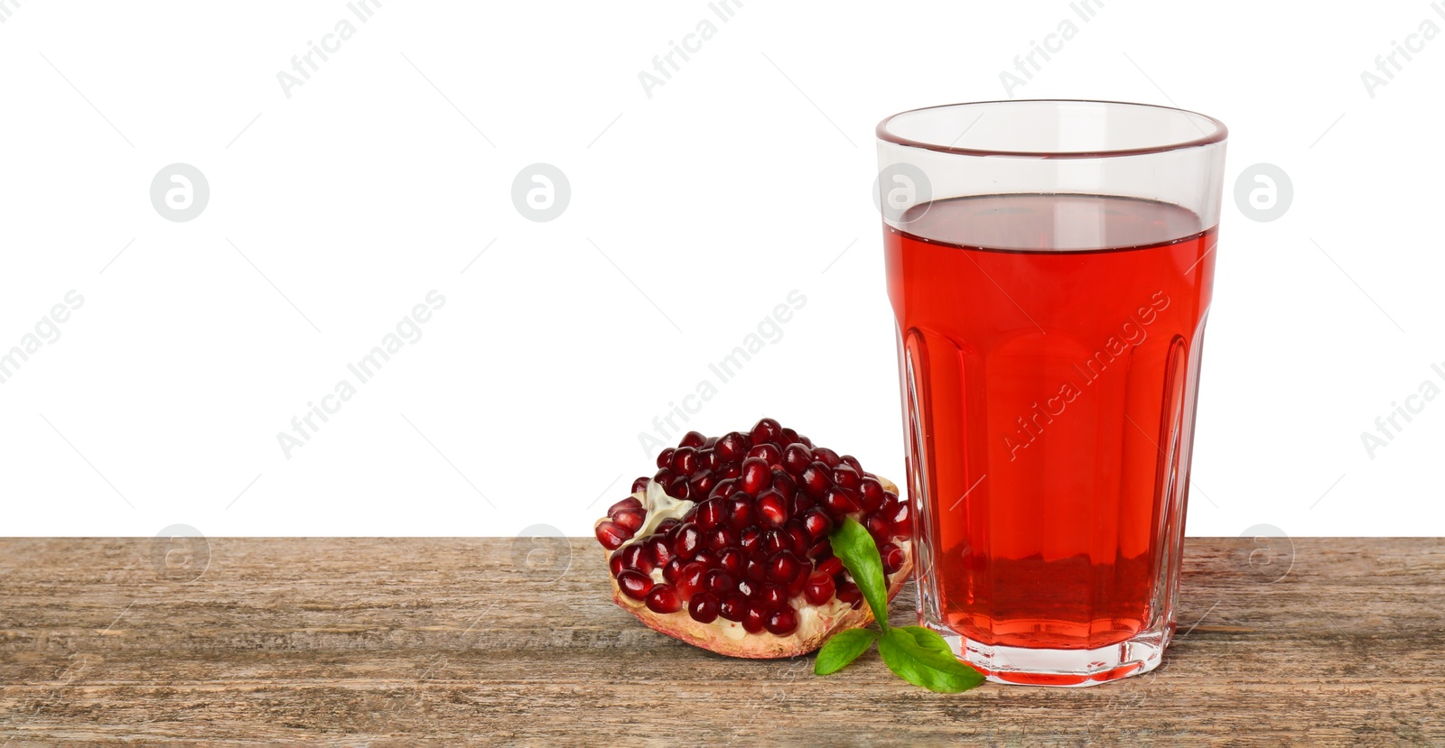 Photo of Refreshing pomegranate juice in glass, leaves and fruit on wooden table against white background. Space for text