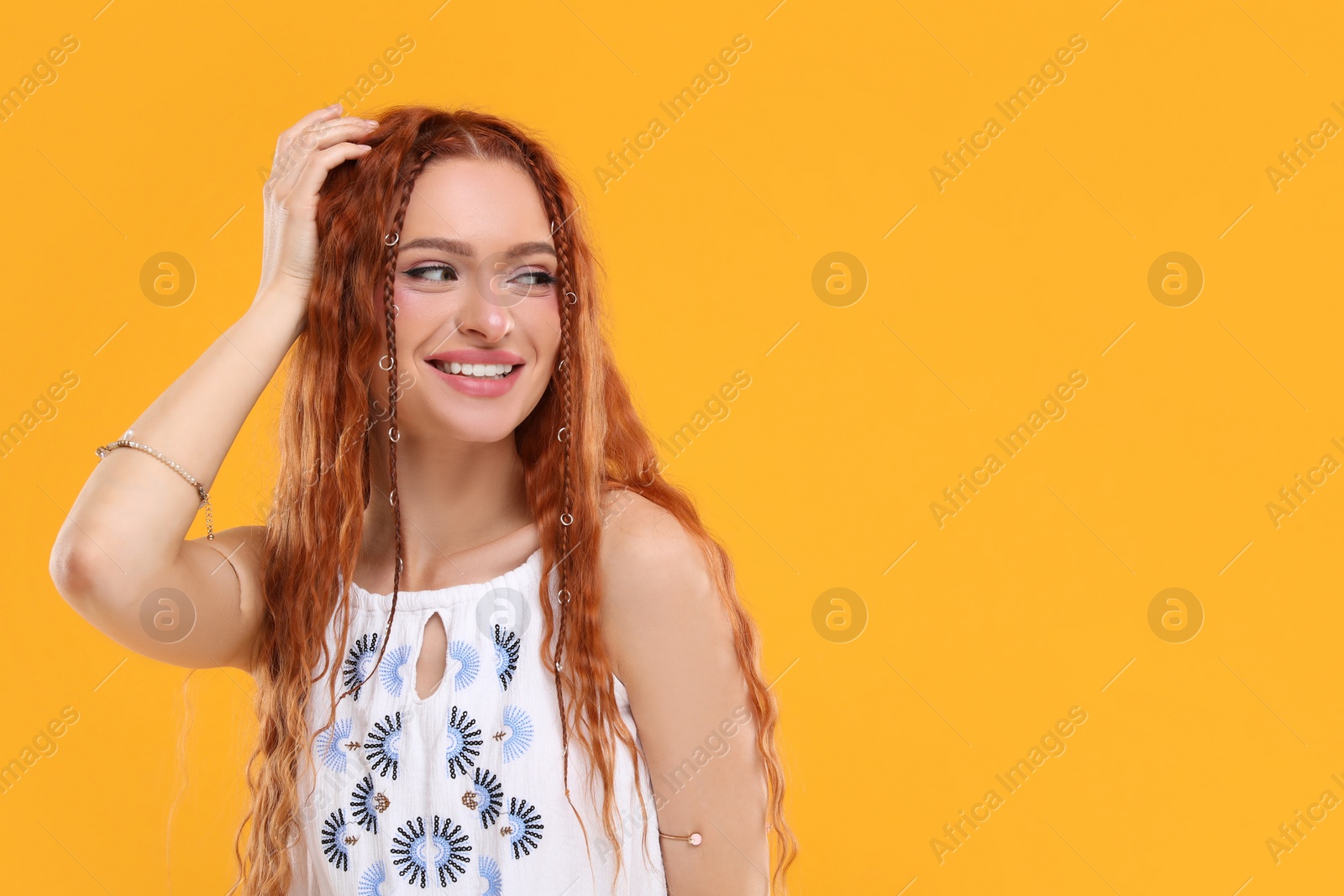 Photo of Beautiful young hippie woman on orange background, space for text