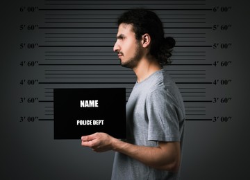 Image of Criminal mugshot. Arrested man with blank card against height chart