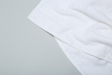 Photo of White terry towel on light grey background, top view. Space for text