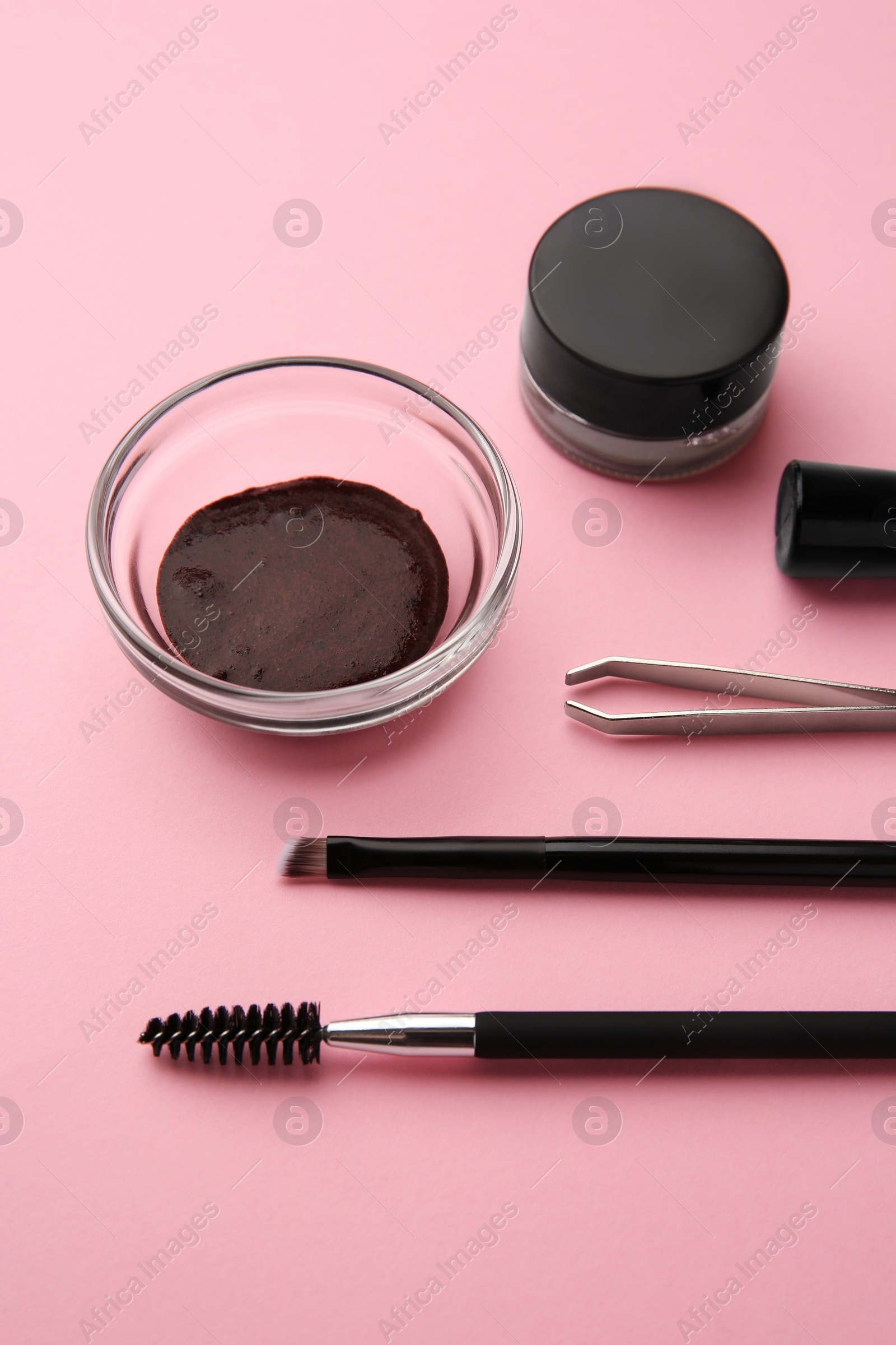 Photo of Eyebrow henna and professional tools on pink background