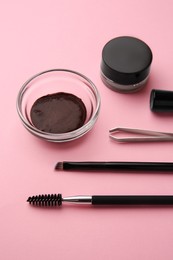 Photo of Eyebrow henna and professional tools on pink background