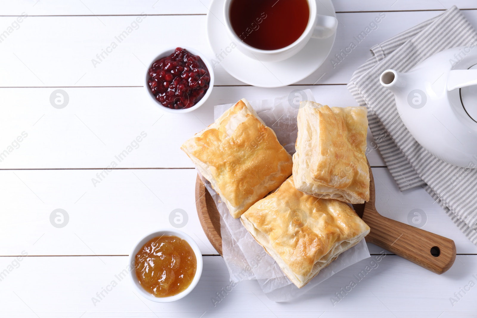 Photo of Delicious puff pastry served on white wooden table, flat lay. Space for text