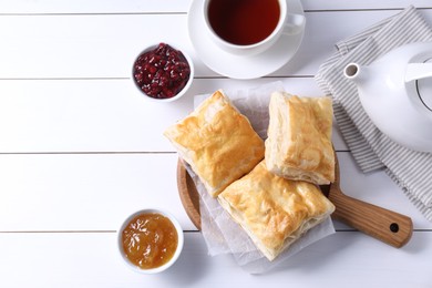 Delicious puff pastry served on white wooden table, flat lay. Space for text