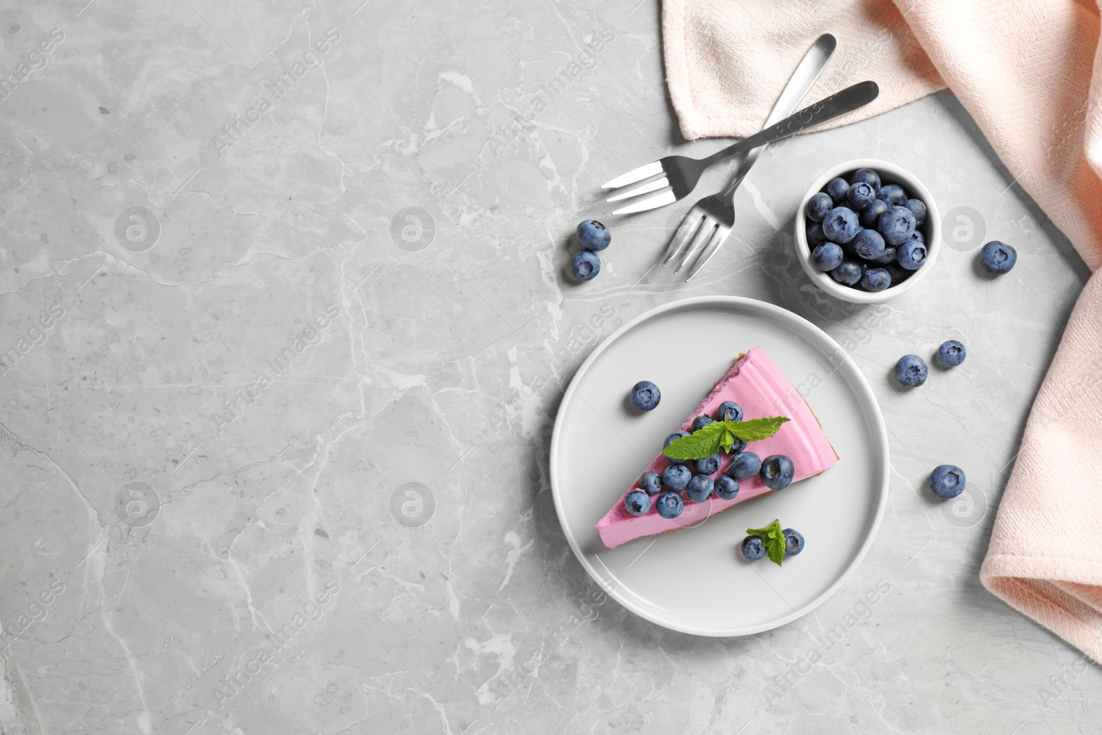 Photo of Flat lay composition of tasty blueberry cake on grey table. Space for text