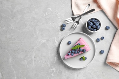 Flat lay composition of tasty blueberry cake on grey table. Space for text