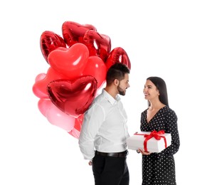Happy young couple with heart shaped balloons and gift box isolated on white. Valentine's day celebration
