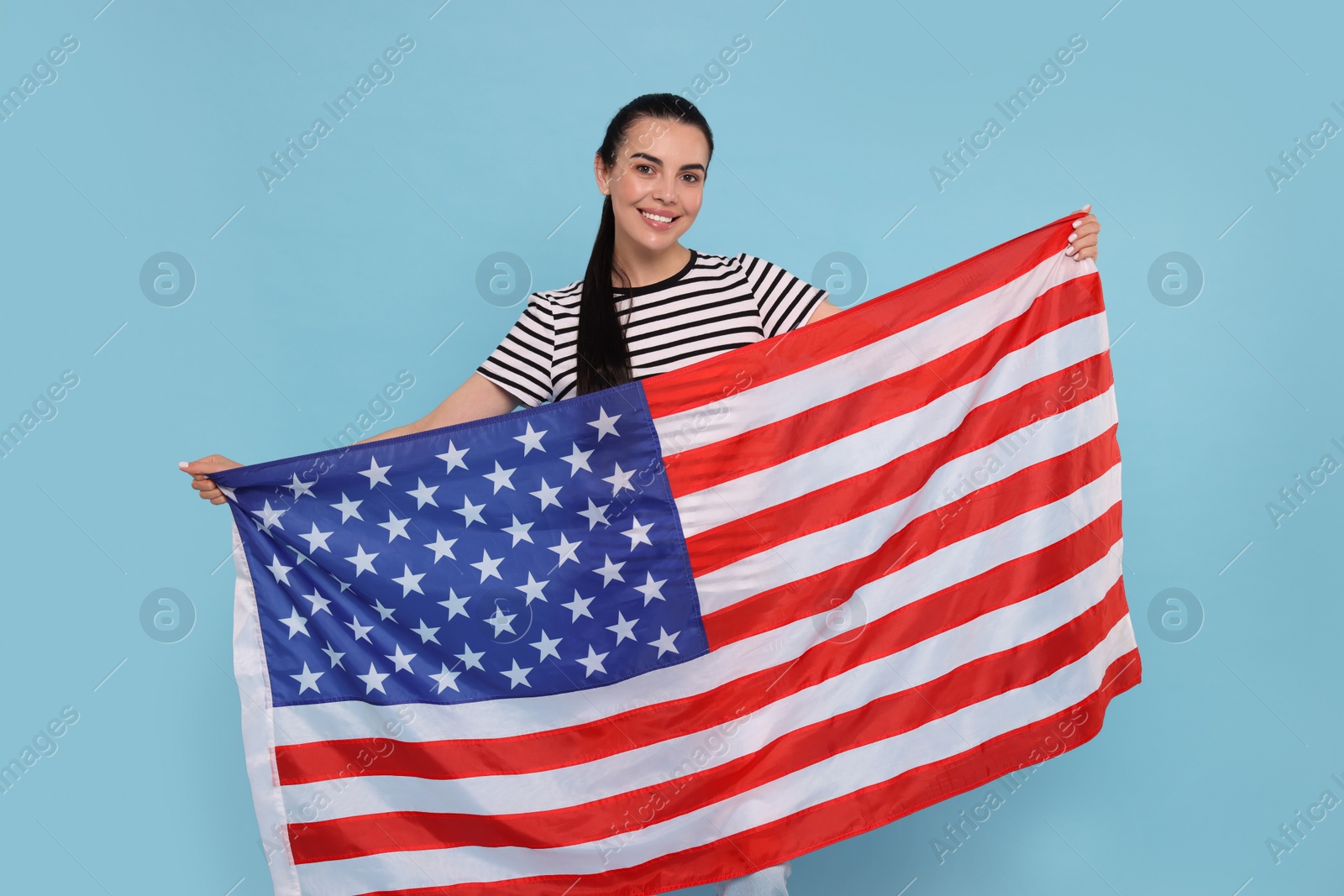 Photo of 4th of July - Independence Day of USA. Happy woman with American flag on light blue background