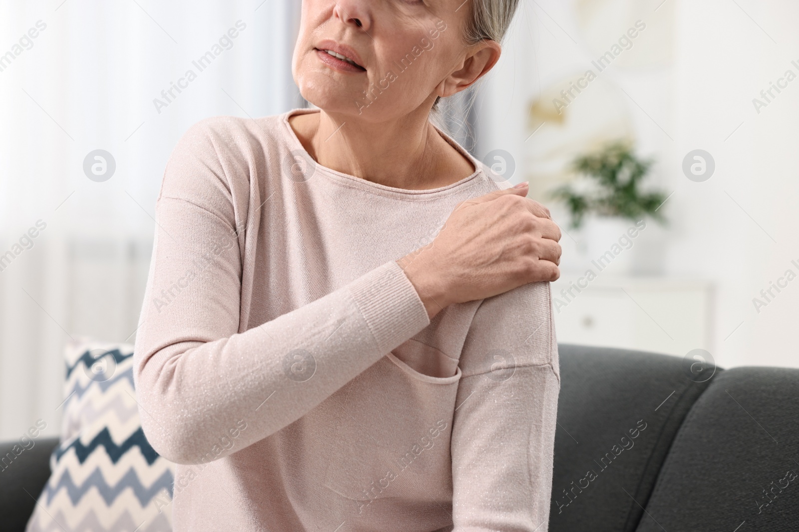 Photo of Arthritis symptoms. Woman suffering from pain in shoulder at home, closeup