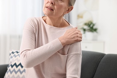 Arthritis symptoms. Woman suffering from pain in shoulder at home, closeup