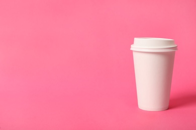 Photo of Takeaway paper coffee cup on pink background. Space for text