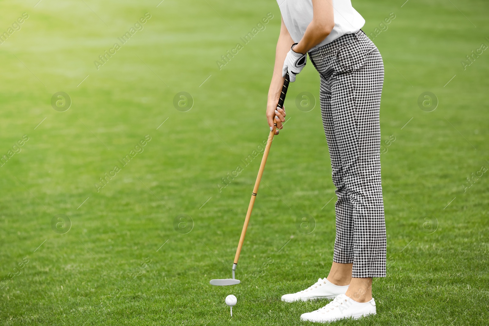 Photo of Woman playing golf on green course. Sport and leisure