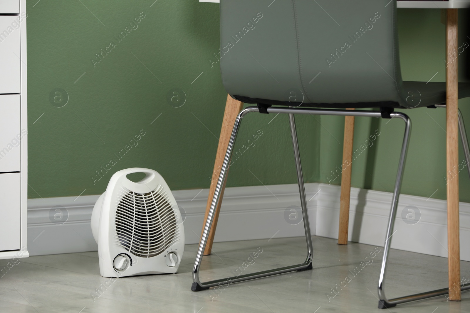 Photo of White electric fan heater on floor in room