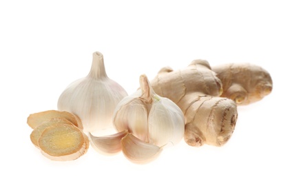 Photo of Ginger and fresh garlic on white background. Natural cold remedies