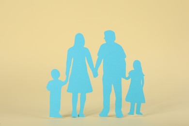 Photo of Paper family figure on beige background. Child adoption concept