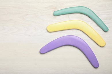 Photo of Boomerangs on white wooden background, flat lay. Space for text