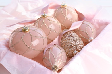 Photo of Set of beautiful Christmas baubles and ribbon in box, closeup