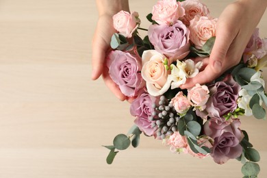 Florist creating beautiful bouquet at table, top view. Space for text