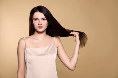 Photo of Portraitbeautiful young woman with healthy strong hair on beige background