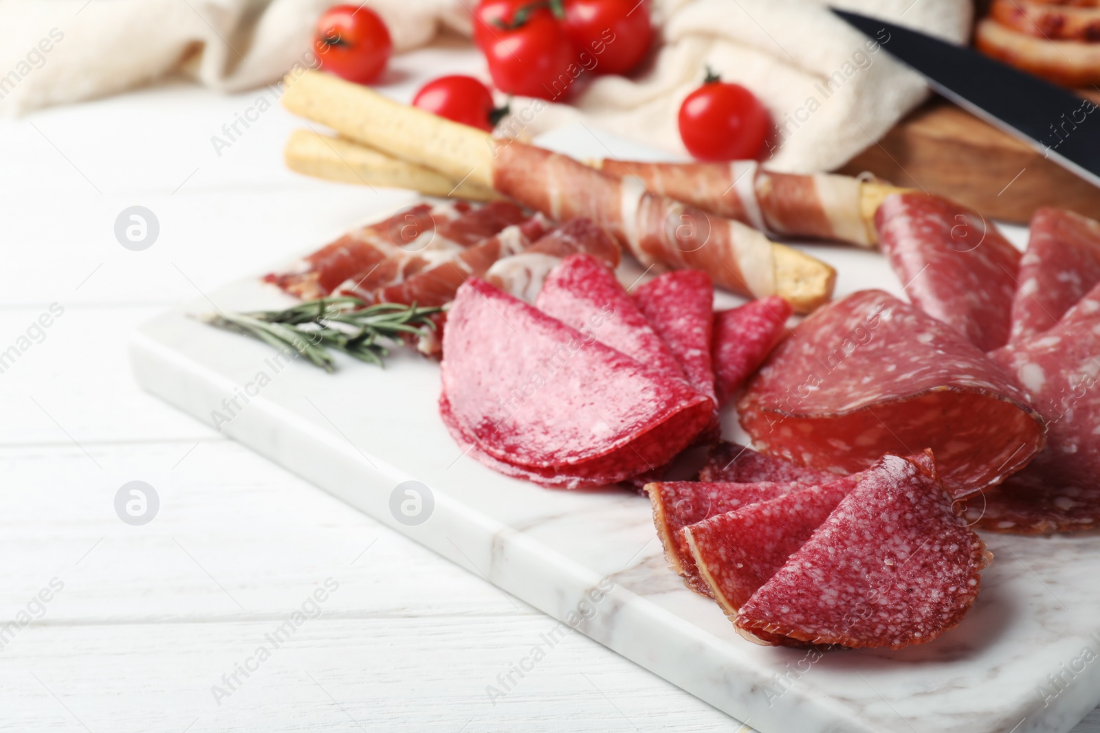 Photo of Cutting board with different sliced meat products served on table