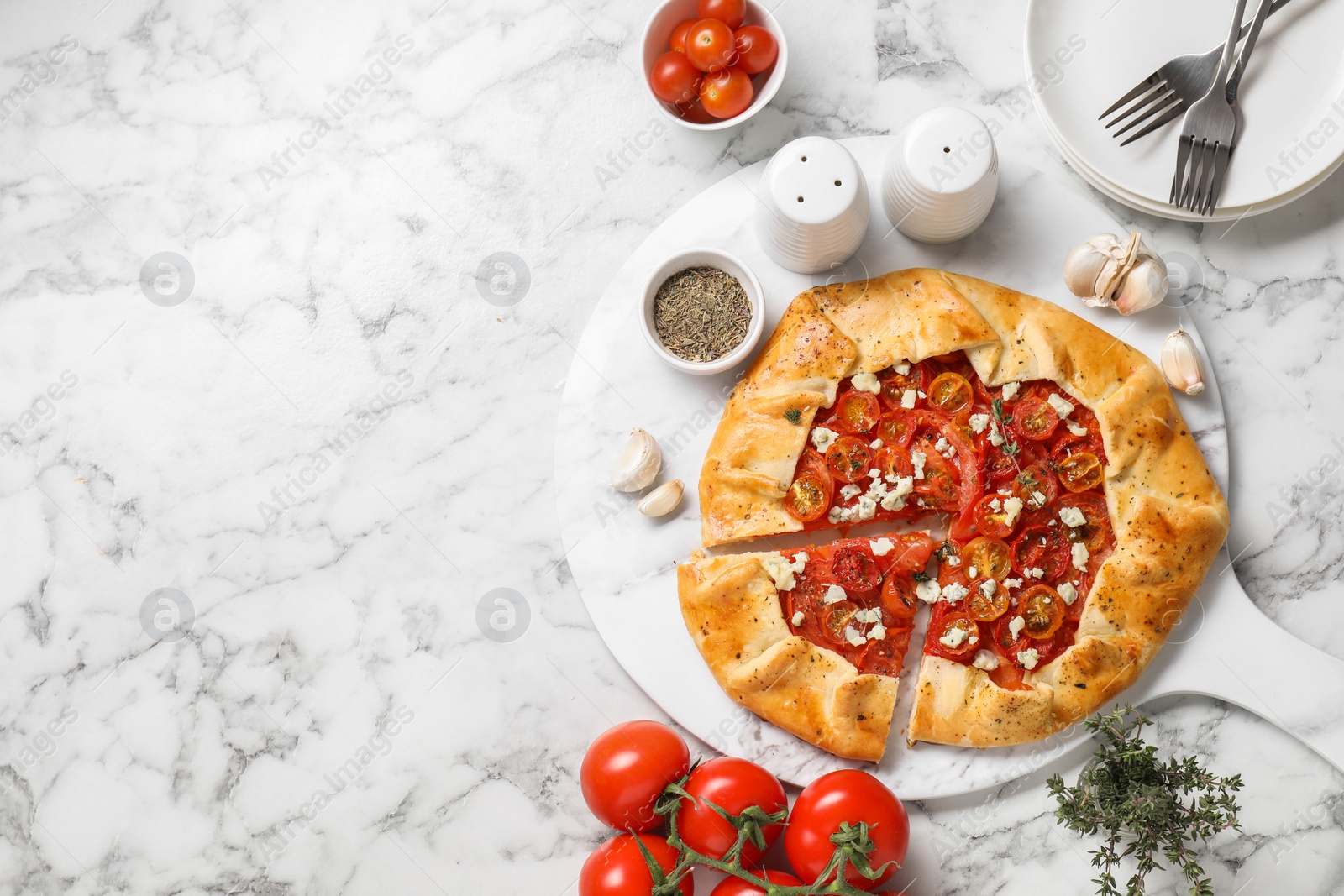 Photo of Flat lay composition of tasty galette with tomato, thyme and cheese (Caprese galette) on white marble table. Space for text
