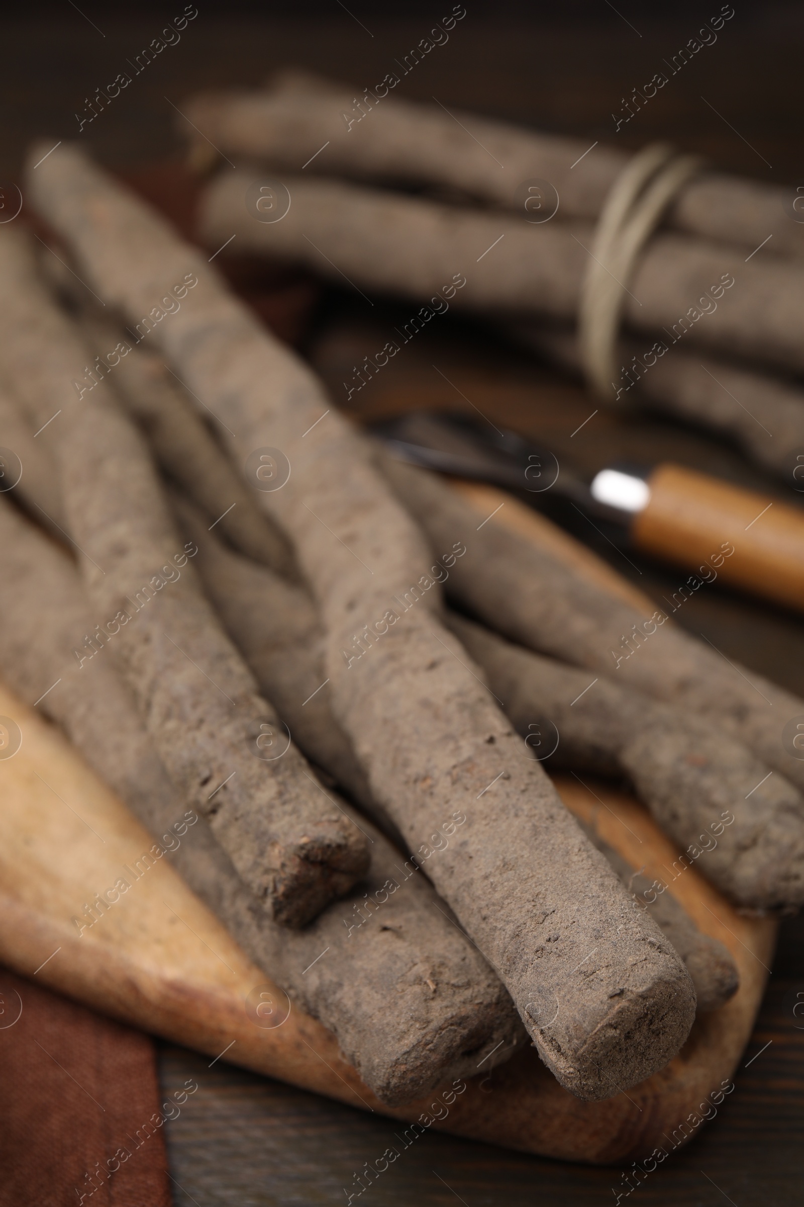 Photo of Raw salsify roots on wooden table, closeup