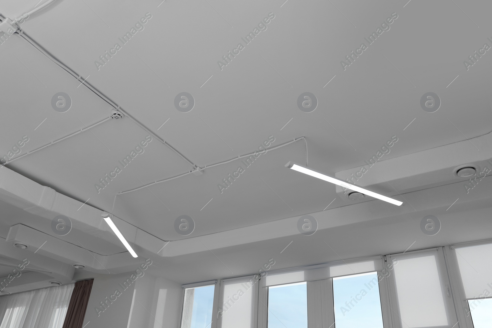 Photo of White ceiling with modern lighting in office