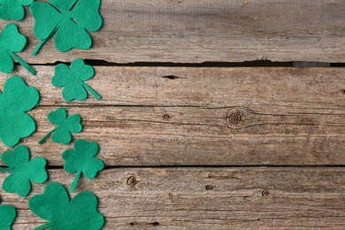 St. Patrick's day. Decorative clover leaves on wooden background, flat lay. Space for text