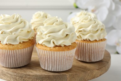 Photo of Tasty vanilla cupcakes with cream on white table, closeup