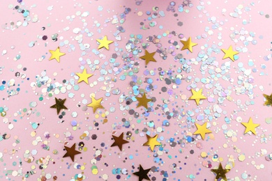 Photo of Shiny glitter on light pink background, above view