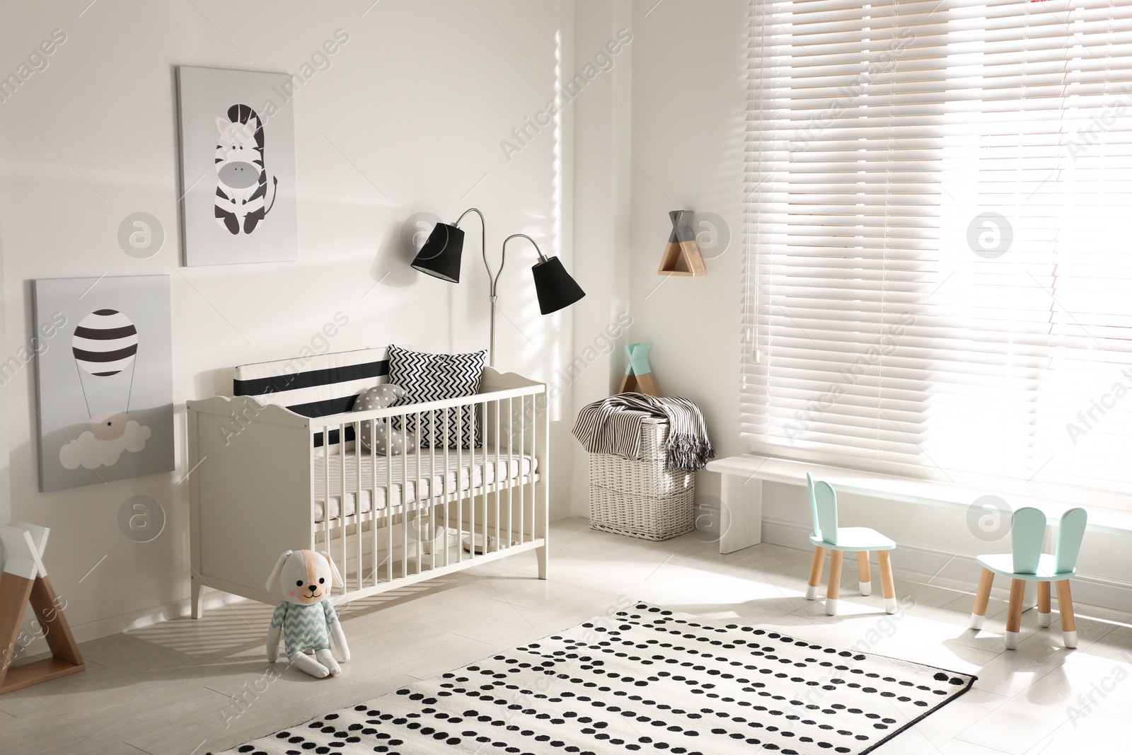 Photo of Cute baby room interior with crib and decor elements