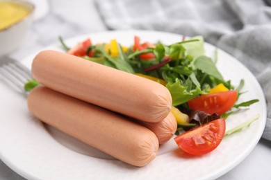 Delicious boiled sausages with salad on table, closeup