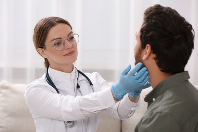 Doctor in gloves examining man`s oral cavity indoors