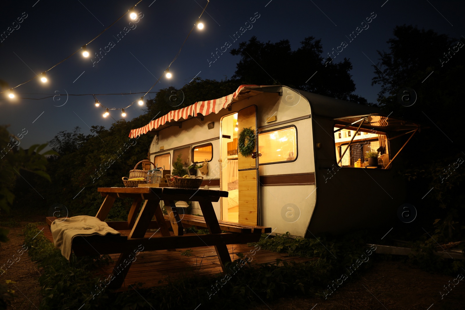 Photo of Beautiful view of motorhome outdoors at night. Summer camping