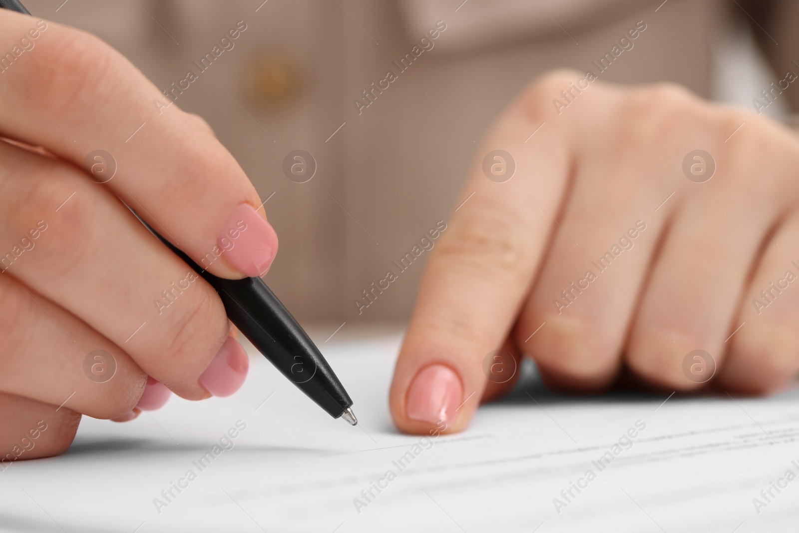 Photo of Woman signing document with pen, closeup view