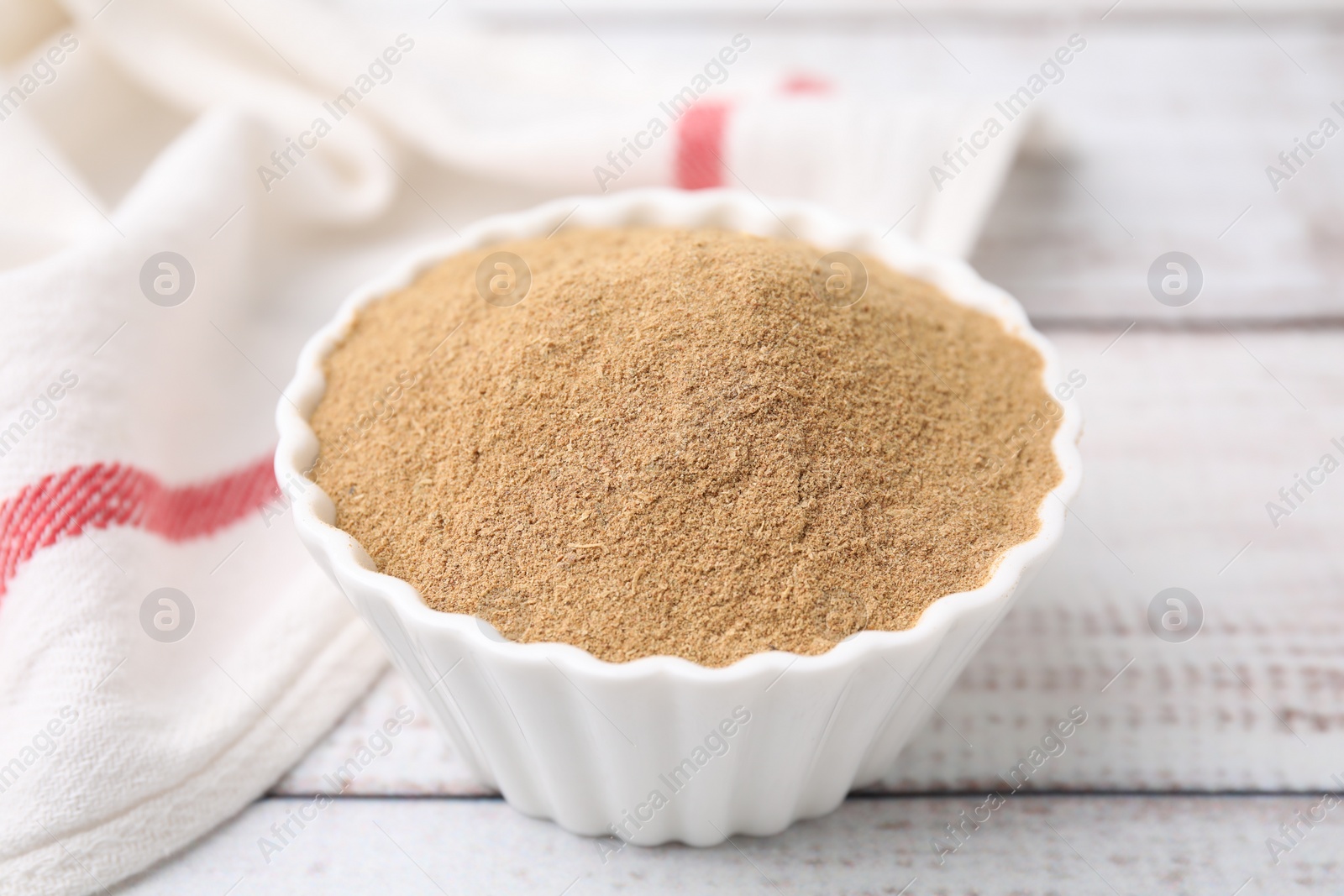 Photo of Dietary fiber. Psyllium husk powder in bowl on wooden table, closeup