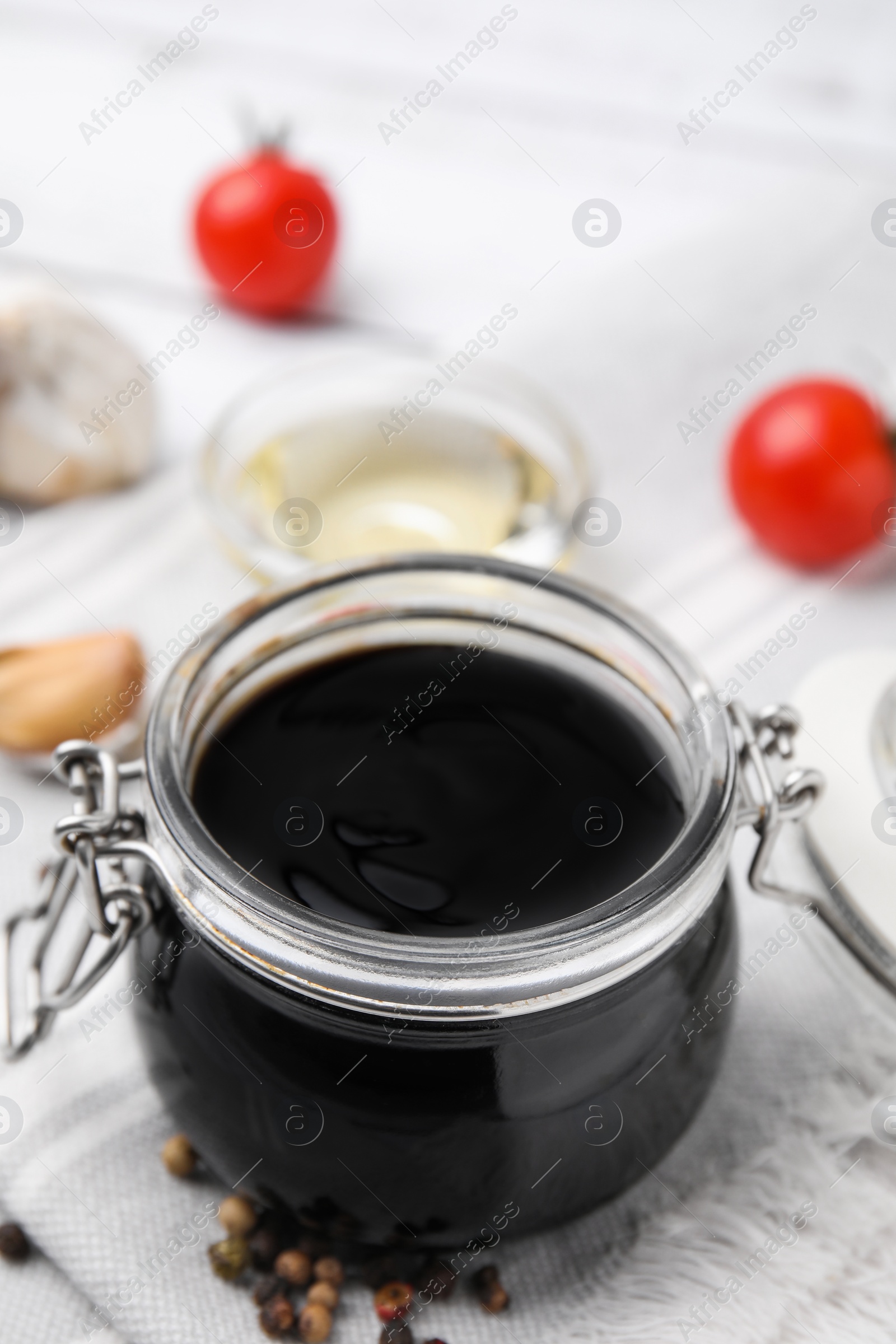 Photo of Organic balsamic vinegar and cooking ingredients on white table, closeup