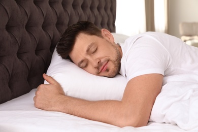 Photo of Handsome man sleeping on pillow at home. Bedtime