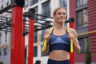 Photo of Athletic woman with fitness elastic band at outdoor gym