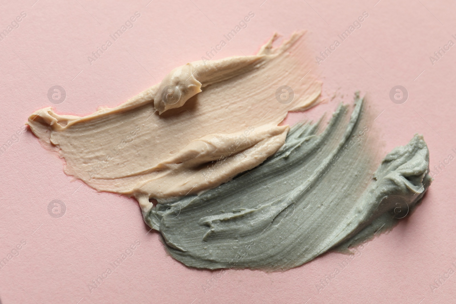 Photo of Samples of face mask on pink background, flat lay