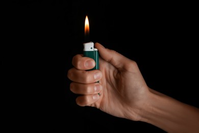 Photo of Woman holding green lighter on black background, closeup