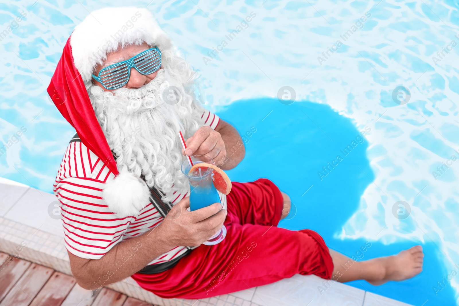 Photo of Authentic Santa Claus with cocktail near pool at resort