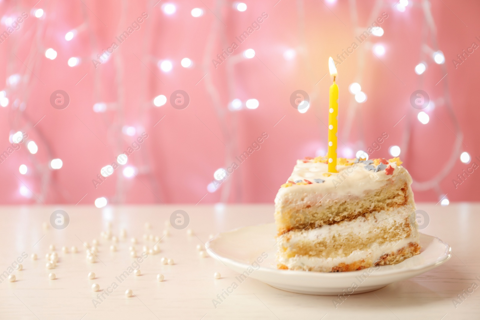 Photo of Slice of delicious birthday cake with candle on table