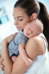 Photo of Young woman with her newborn baby at home
