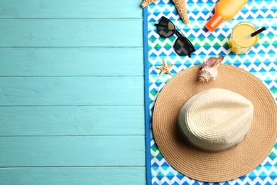 Photo of Beach accessories and drink on light blue wooden table, flat lay. Space for text