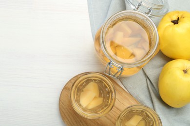 Photo of Delicious quince drink and fresh fruits on white wooden table, top view. Space for text