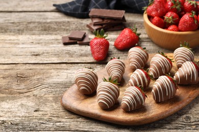 Photo of Delicious chocolate covered strawberries on wooden table. Space for text