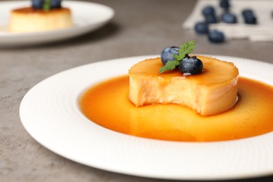 Delicious pudding with caramel and blueberries on grey table, closeup